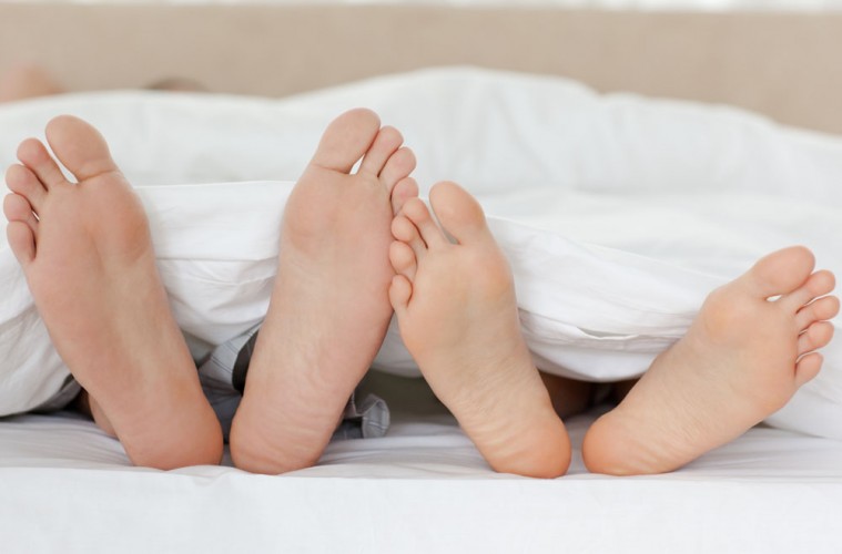 Close up of couple's feet while relaxing in their bed